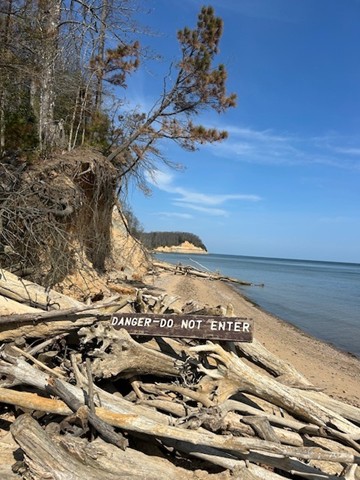 Danger sign on the beach prohibiting visitors from going on the cliffs. 